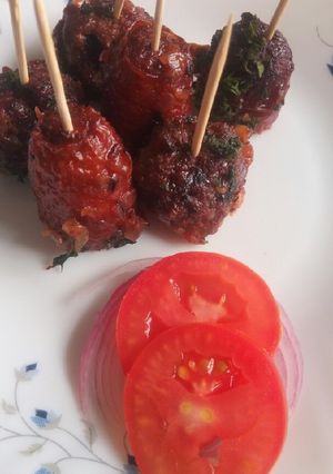 A picture of Meat balls and beef sausages bitings in sauce.