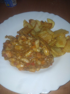 Una foto de Guiso de judías con salsa y papas fritas