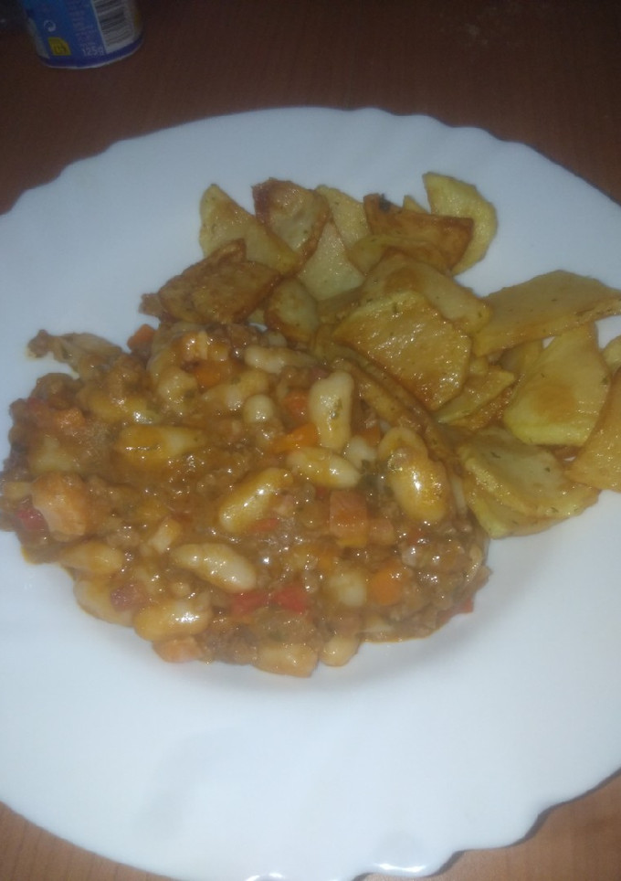 Una foto de Guiso de judías con salsa y papas fritas