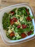 Ensalada de arúgula, tomates secos y queso
