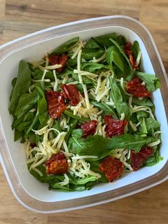 Una foto de Ensalada de arúgula, tomates secos y queso