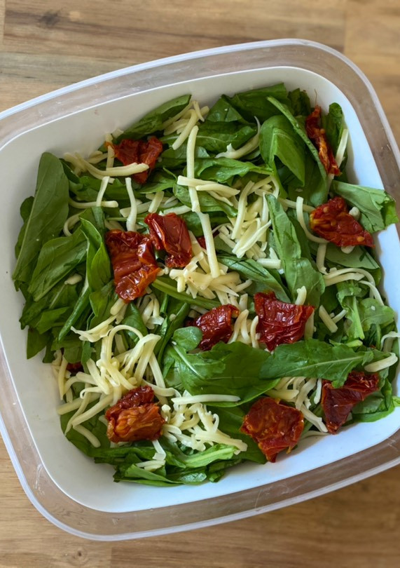 Una foto de Ensalada de arúgula, tomates secos y queso