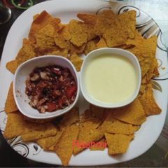 A picture of Nachos with tomato salsa.