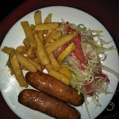 A picture of Sausage with few chips and salad.