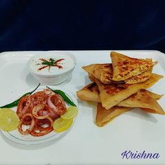 A picture of Veg Mughlai Paratha with lacha pyaz and Dahi.