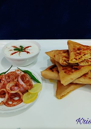 A picture of Veg Mughlai Paratha with lacha pyaz and Dahi.