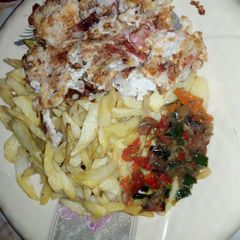 A picture of Chips & egg with sauce.