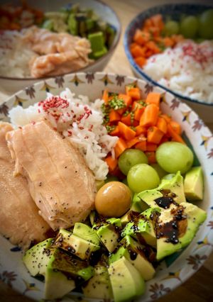 Una foto de Poke de arroz con filete de salmón, uvas, zanahoria y aguacate