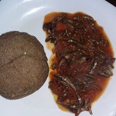 A picture of Stewed Omena served with brown ugali.