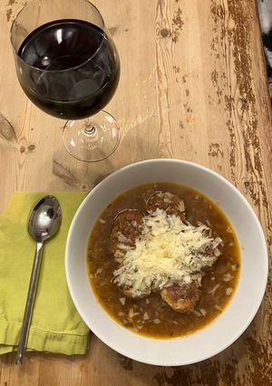 A picture of Onion soup with chicken meatballs.