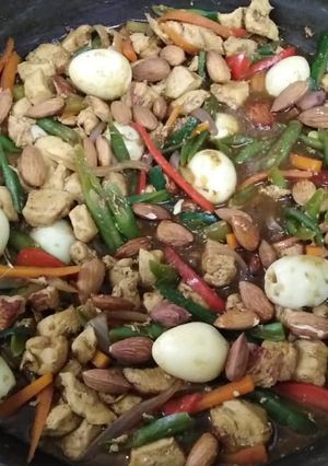 Una foto de Pollo saltado con huevitos de codorniz y almendras