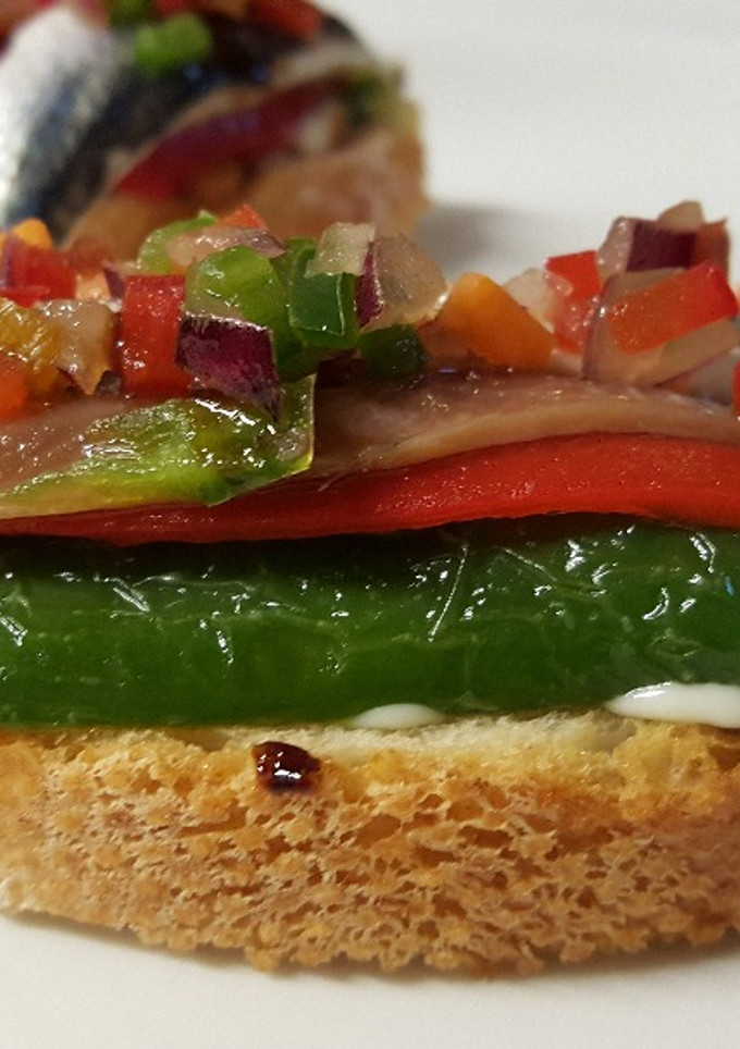 Una foto de Tapa de anchoas, pimiento verde y rojo