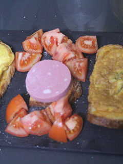 Una foto de Tortilla con tomate seco sobre pan de payés