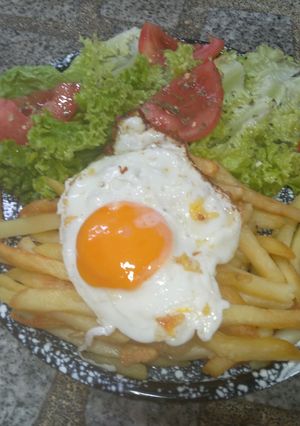 Una foto de Ensalada de Lechuga y Tomate con Papas Fritas y Huevo Frito