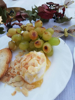 Una foto de Queso de cabra fresco con miel y uvas a la plancha