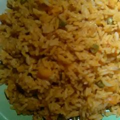 A picture of Jellof rice with green beans and carrot.