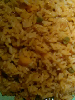 A picture of Jellof rice with green beans and carrot.