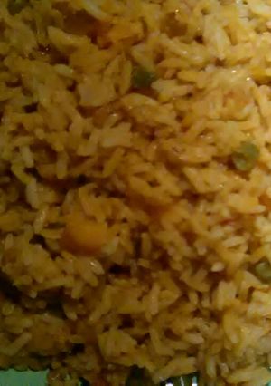 A picture of Jellof rice with green beans and carrot.
