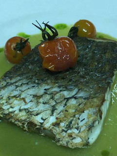 Una foto de Corvina negra con crema de espárragos y cherris salteados