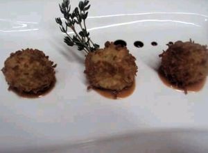 Una foto de Croquetas de yautia empanadas con coco en salsa de guayaba