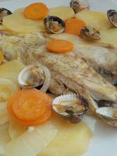 Una foto de Lubina a la naranja al horno y berberechos