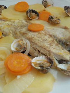 Una foto de Lubina a la naranja al horno y berberechos