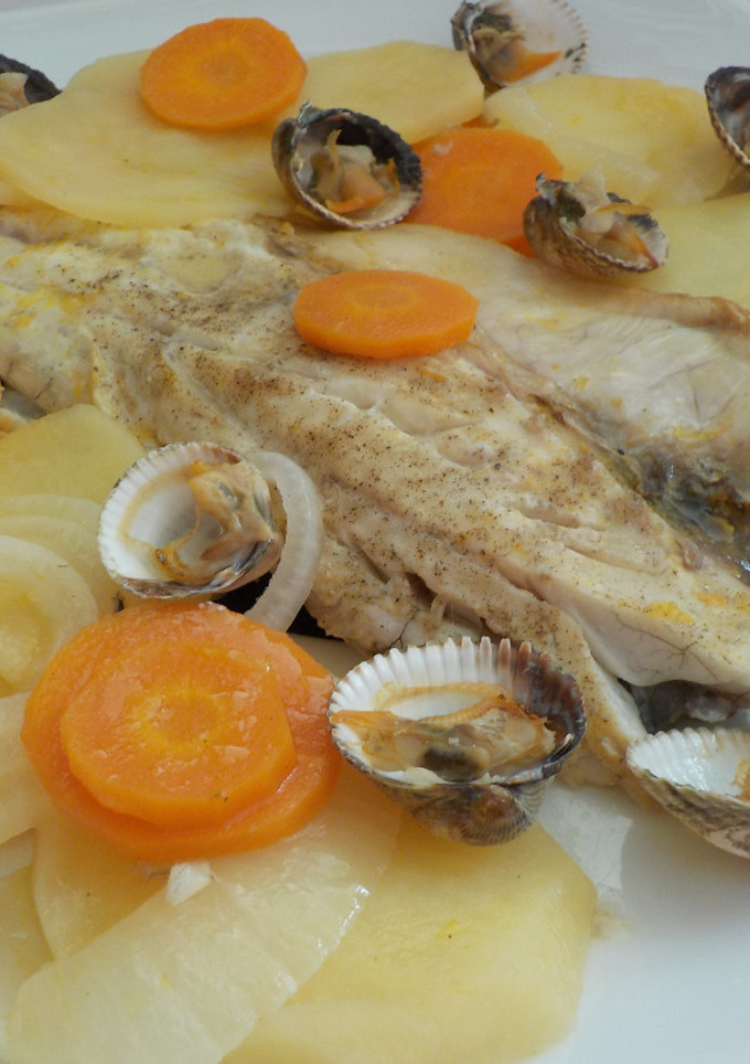 Una foto de Lubina a la naranja al horno y berberechos