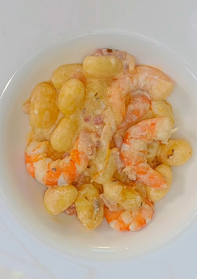 Una foto de Ñoquis con bacon y langostinos