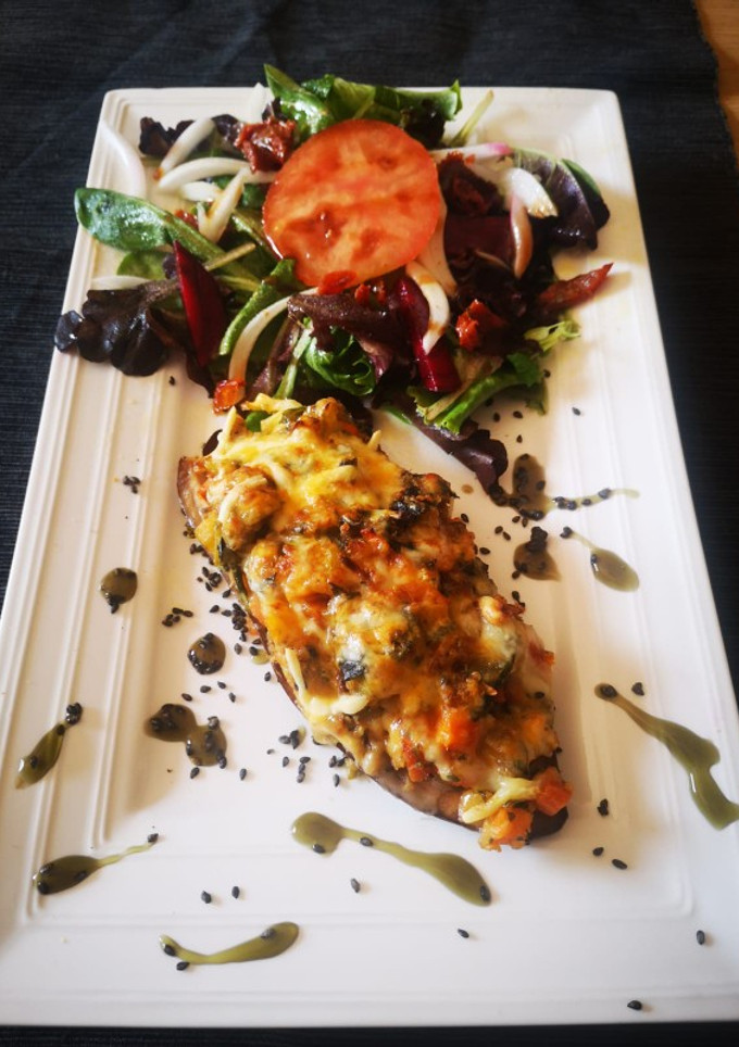 Una foto de Berenjena rellena de verduras y quinoa