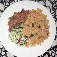 A picture of Egg and fish sauce served with veggies Jollof rice.