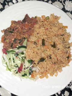 A picture of Egg and fish sauce served with veggies Jollof rice.