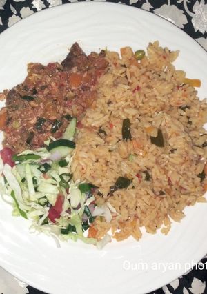 A picture of Egg and fish sauce served with veggies Jollof rice.