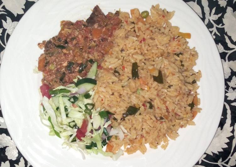 Egg and fish sauce served with veggies Jollof rice