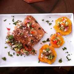 Una foto de Mero a la plancha con pico de gallo y tostones.