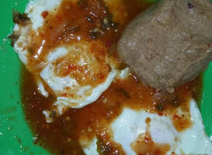 Una foto de Huevos estrellados en salsa de tomate