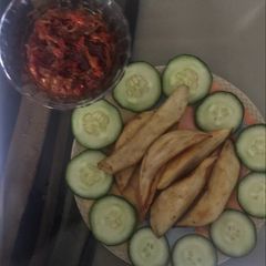 A picture of Fried sweet potatoes garnished with cucumber and sauce to blend.