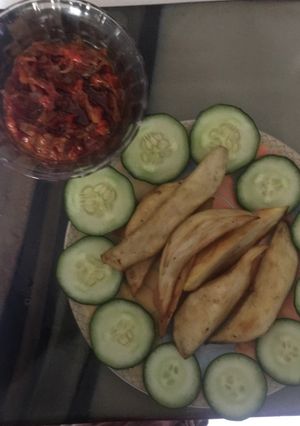 A picture of Fried sweet potatoes garnished with cucumber and sauce to blend.