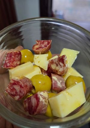 Una foto de Aperitivo de fuet, queso y olivas bañados en vermut y AOVE
