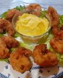 Camarones empanizados acompañados de una salsa holandesa