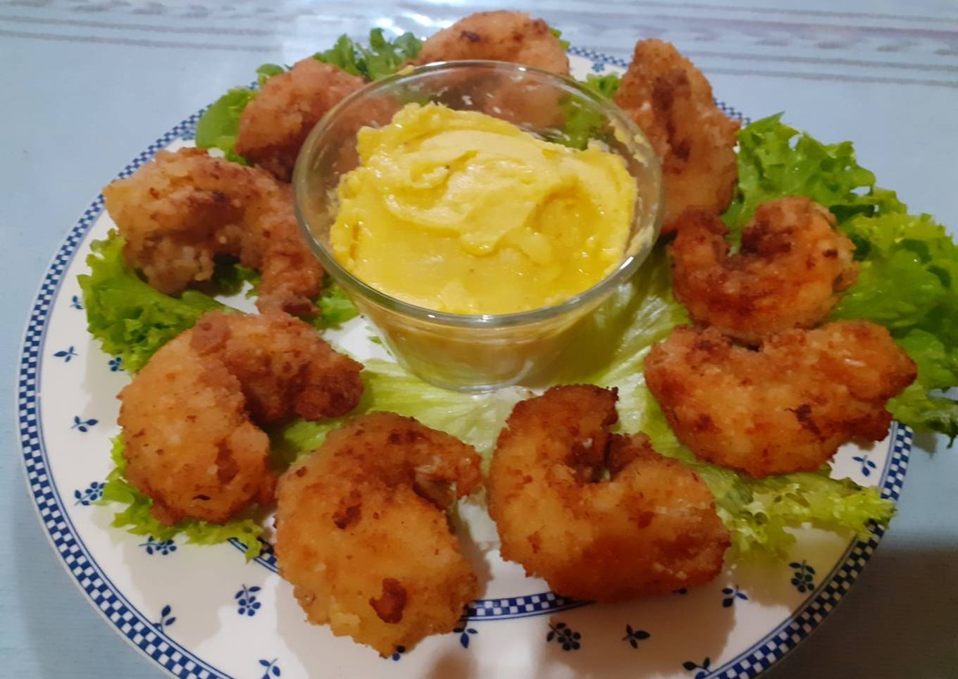 Camarones empanizados acompañados de una salsa holandesa