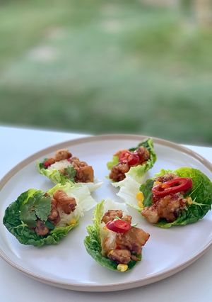 A picture of Beer-battered pork popcorn served with sticky rice and sweet chilli sauce, on little gem.