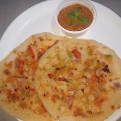 A picture of Rava uttapam with red chutney.