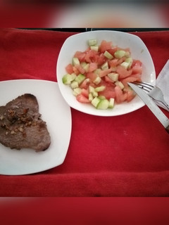 Una foto de Bistec con ensalada de tomate y pepino