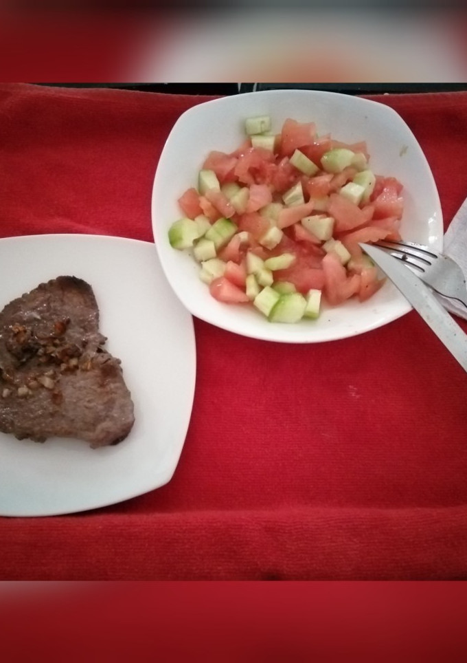 Una foto de Bistec con ensalada de tomate y pepino