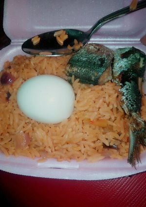 A picture of Delicious jollof rice wix boiled egg md fish.
