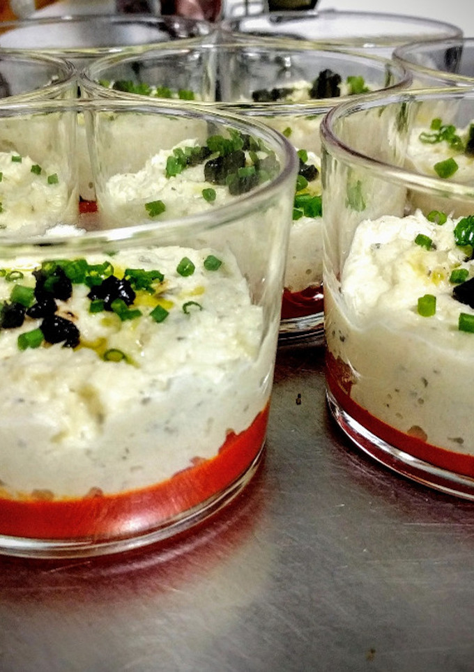 Una foto de Mousse de bacalao confitado con gelatina de piquillo y toques de ajo negro