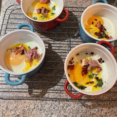 A picture of Baked eggs with cheddar and bacon.