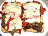 Churrasco de lomo sobre tostadas de pan ciabatta con pimientos y cebolla