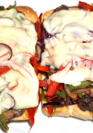 Una foto de Churrasco de lomo sobre tostadas de pan ciabatta con pimientos y cebolla