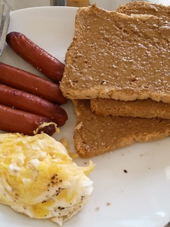 A picture of Eggs Sausages Brown Bread and Peanut Butter.